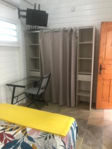 a bedroom with a desk and a table and a curtain at Casamango in Basse-Terre