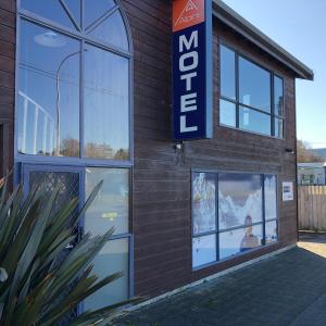 a store with a sign on the side of a building at Alpine Motel in Ohakune