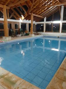 拉安戈斯图拉镇Cabañas Añahue的建筑物内铺有蓝色瓷砖的大型游泳池