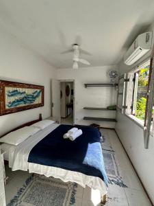 ein Schlafzimmer mit einem Bett mit einer blauen Decke in der Unterkunft Vila dos Tangarás, Casa 1 Praia, a 30m do mar in Toque Toque Grande