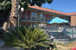 a building with a blue umbrella and a table and chairs at Fresno Inn in Fresno