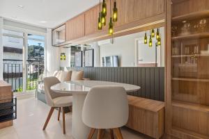 a dining room with a white table and chairs at Apartamento Viña del Aire 1 dorm by Achei Gramado in Gramado