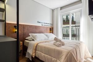 a bedroom with a bed with a teddy bear on it at Apartamento Viña del Aire 1 dorm by Achei Gramado in Gramado
