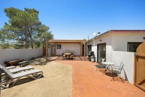 a patio with chairs and tables and a building at Mesa View Homestead - Cozy, 360 Views & Tranquility! home in Pioneertown