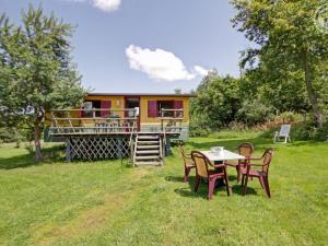 une table et des chaises devant une maison dans l'établissement Roulotte du Chat qui Pète: Séjour Paisible et Animaux Bienvenus - FR-1-496-308, à Saint-Germain-Lespinasse