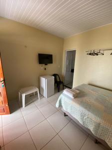 a bedroom with a bed and a flat screen tv at Chico Caranguejo da Baleia in Itapipoca