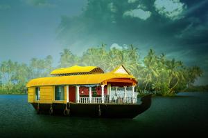 a boat in the water with a house on it at Sreekrishna Houseboat - VACCINATED STAFF in Kumarakom