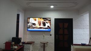 a tv hanging on a wall with a car on it at Appartement dunes de Martil in Martil