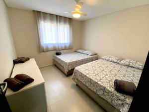 une chambre avec deux lits et une fenêtre dans l'établissement Casa 3 Condomínio Pé na Areia Ponta do Papagaio, à Palhoça 33 autres photos