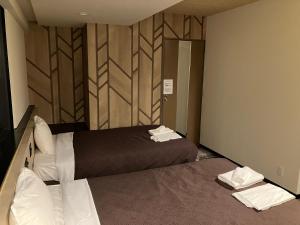 Postel nebo postele na pokoji v ubytování HOTEL LiVEMAX BUDGET Amagasaki