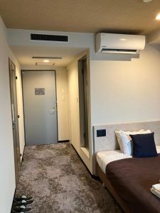 Postel nebo postele na pokoji v ubytování HOTEL LiVEMAX BUDGET Amagasaki