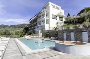 un bâtiment avec une piscine en face d'un bâtiment dans l'établissement Hotel Benacus Panoramic, à Riva del Garda