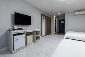 a hotel room with a bed and a television at New Korea Resort in Jeju