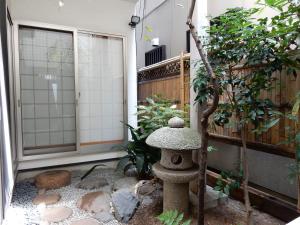 京都市にある宿屋　三坊の庭園の隅に座る石灯篭