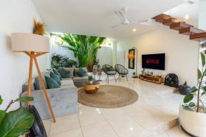 a living room with a couch and a tv at Boho-chic villa near Cafè Del Mar, 5-minute walk to beach in Canggu