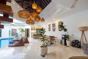 a living room with potted plants and a pool at Boho-chic villa near Cafè Del Mar, 5-minute walk to beach in Canggu