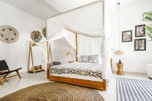 a bedroom with a canopy bed and a rug at Boho-chic villa near Cafè Del Mar, 5-minute walk to beach in Canggu