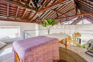 a bedroom with a bed and a table in a room at Boho-chic villa near Cafè Del Mar, 5-minute walk to beach in Canggu