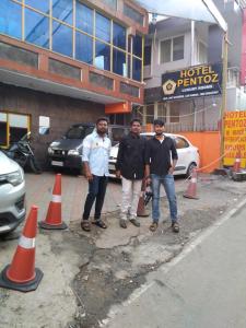 three men standing inront of orange cones in front of a hotel at Hotel PENTOZ - Rose Garden, Ooty in Ooty