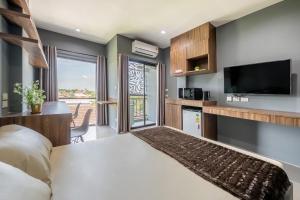 a bedroom with a large bed and a television at Panvadee Boutique House in Ban Bang Phang
