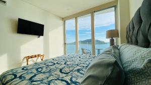 ein Schlafzimmer mit einem Bett mit Blick auf das Meer in der Unterkunft Condominios de lujo en el corazón de la Zona Dorada en Camino Al Mar. in Mazatlán + 103 Fotos