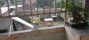 a balcony with plants and a table and chairs at Javalindra Homestay Tour and Travel in Banyuwangi