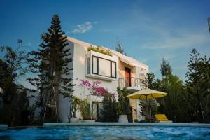 a house with a swimming pool in front of a building at Montagne Residence in Kampot