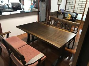 a wooden table and chairs in a room at Guest House Ken-Ken in Hota