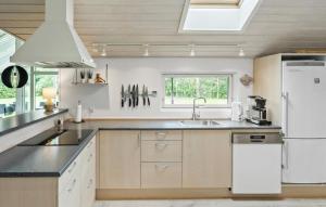 a kitchen with a white refrigerator and a sink at Cozy Home In Idestrup With Sauna in Marielyst +21 photos
