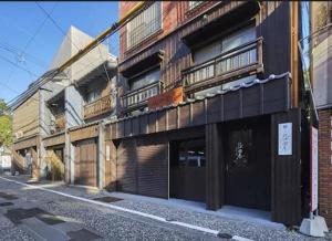 长崎おやど紀伊国屋銀屋町弐館的街道上一栋建筑旁边是一栋带阳台的建筑