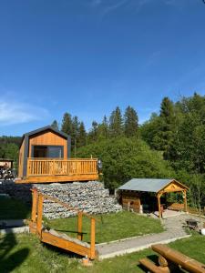 a log cabin with a deck on a rocky hill at Domek Cud Miód in Wisła