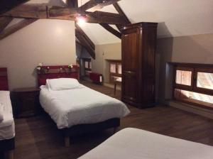 a bedroom with two beds in a room with wooden ceilings at Domaine de Noyer in Saint-Christophe-en-Brionnais