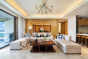 三亚Haiyun Island - Mid-Levels Peninsula Future Water World 2 bedrooms, 2 bathrooms and 1 living room luxury apartment suite的客厅配有白色家具和吊灯。