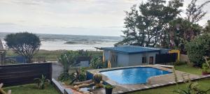 a house with a swimming pool next to the ocean at Blue Space Beach Shack in Hibberdene