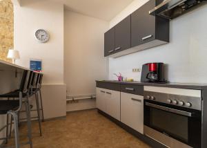 a kitchen with a stove and a clock on the wall at Ferienwohnung Amalie in Apolda