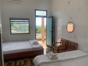 una habitación con dos camas y una ventana y un espejo en Nhà Nghỉ Phong Quỳnh - Đảo Phú Quý, en Cu Lao Thu