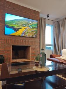 ein Wohnzimmer mit einem Kamin und einem Flachbild-TV in der Unterkunft Casa barrio privado in Laguna Brava
