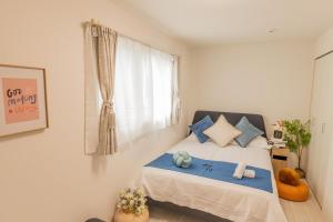 a bedroom with a bed with blue pillows and a window at 桜の川24 池袋駅 6分 10人3卧室别墅丨Ikebukuro 6 minutes 2-8 people in Tokyo