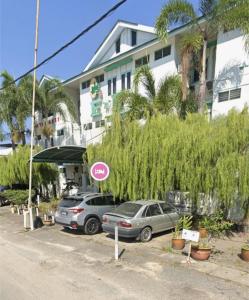 two cars parked in a parking lot in front of a building at EnE Sri Cemerlang in Kota Bharu