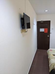 a room with a door and a television on a wall at EnE Sri Cemerlang in Kota Bharu +22 photos
