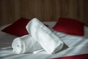 a stack of white towels on a bed at Brit Hotel Plaisance A9/A61 in Narbonne