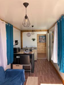 a kitchen with blue curtains and a desk in a room at Les Capucines Adult Only in La Plaine des Palmistes