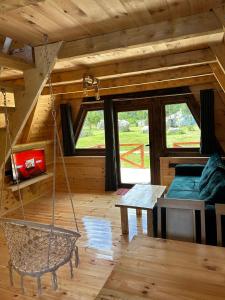 a room with a swing in a log cabin at Etno Cottages Komarnica Authentic Peaceful Mountain Getaway in Šavnik