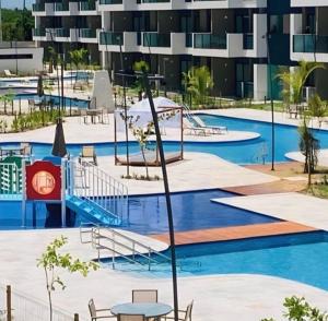 an empty swimming pool with a building in the background at Makia Beach experience Flat 115 A in Porto De Galinhas