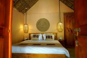 a bedroom with a bed with white sheets and pillows at Gaga Bees Ella in Ella +54 photos