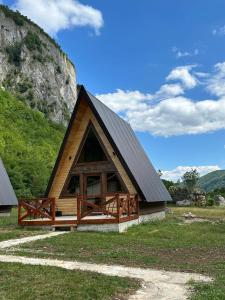 a small cabin with a black roof at Etno apartmani Komarnica in Šavnik