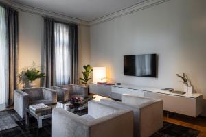 a living room with couches and a flat screen tv at The Nest by Juno Hotel Sofia in Sofia