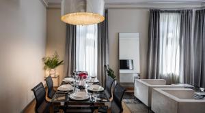 a dining room with a table and chairs and a living room at The Nest by Juno Hotel Sofia in Sofia