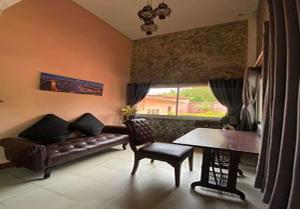 a living room with a couch and a table at Phalaburi resort by dreamhouse in Ban Phala