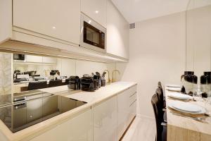a kitchen with white cabinets and a table with chairs at Apartment with terrace - Parc monceau in Paris